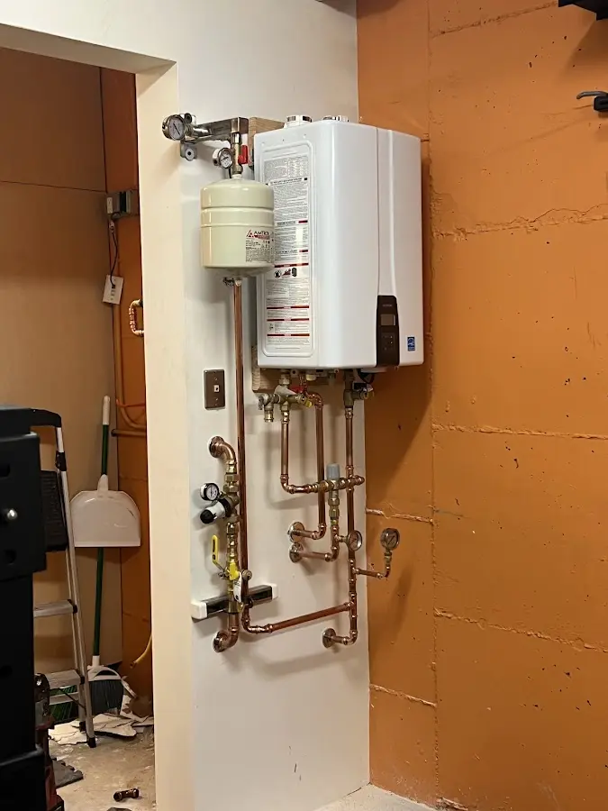 Plumbing technician inspecting water heater connections in Rockwall